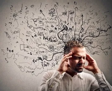Silueta de una persona cuya cabeza se deshace en partículas, imagen de la ansiedad